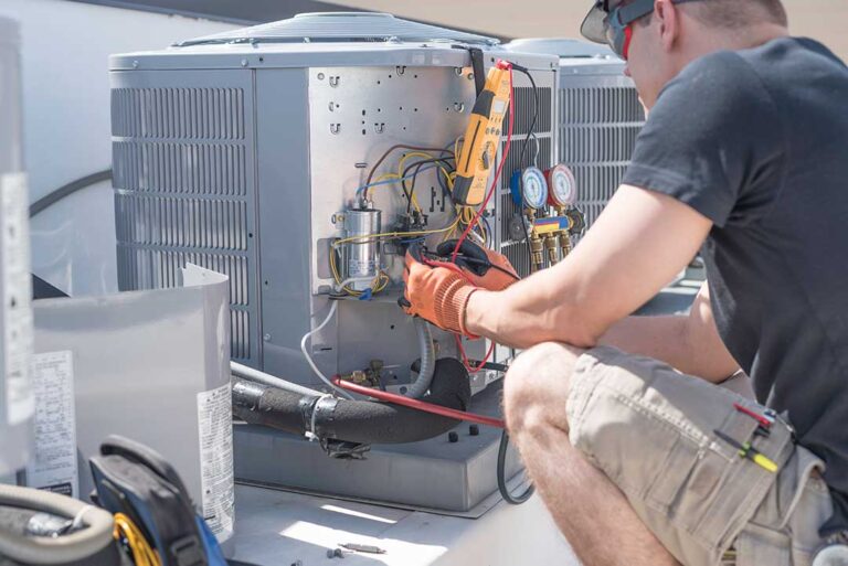 Technician installing an HVAC unit outside a suburban single-family home in warm weather.